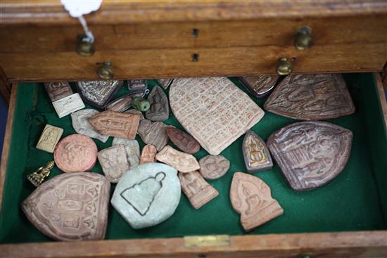 A collection of Buddhist terracotta amulets, chest 82cm